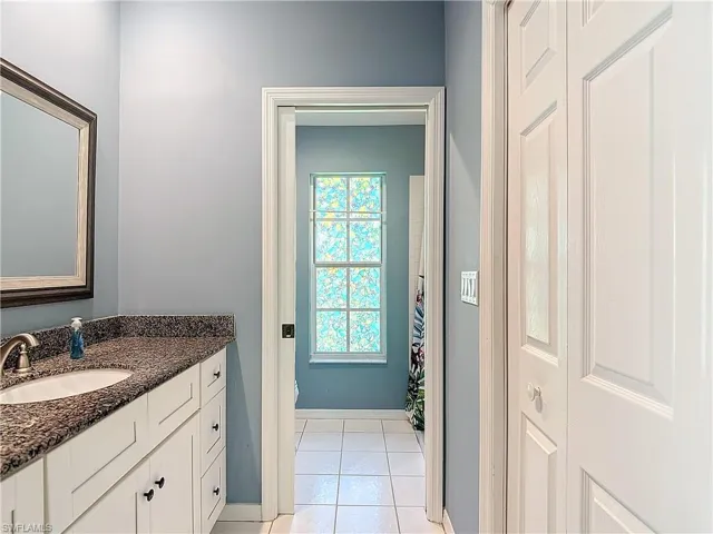 Bathroom with tile floors, vanity, and toilet
