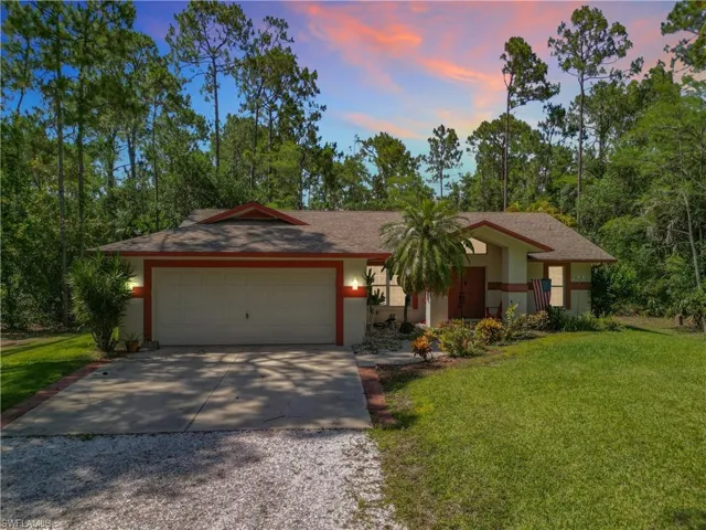 View of front of property featuring a garage and a lawn
