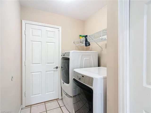 Clothes washing area with independent washer and dryer and light tile floors