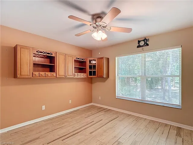 Empty room with ceiling fan and light hardwood / wood-style flooring