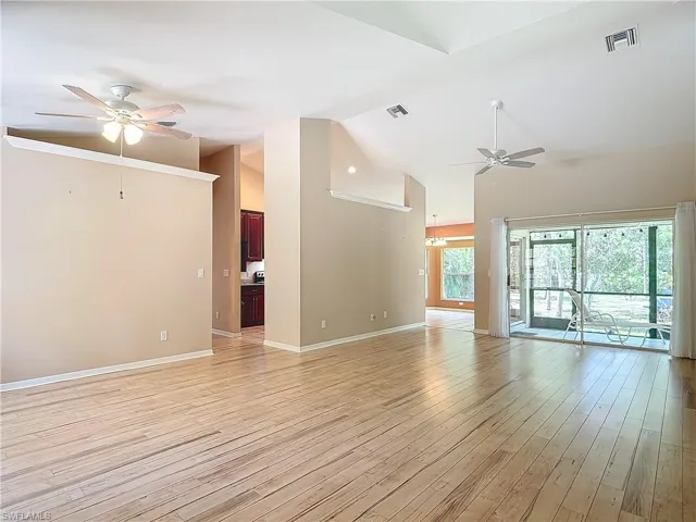 Unfurnished living room with high vaulted ceiling, ceiling fan, and light hardwood / wood-style flooring