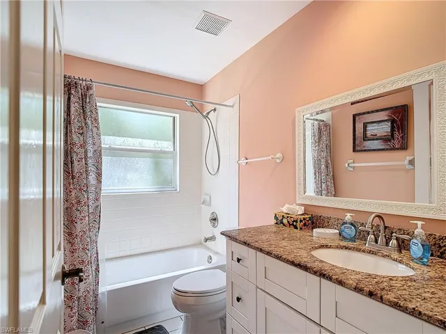 Full bathroom featuring toilet, tile flooring, vanity, and shower / bath combo