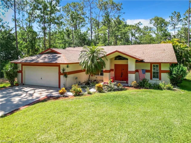 Ranch-style house featuring a garage and a front lawn