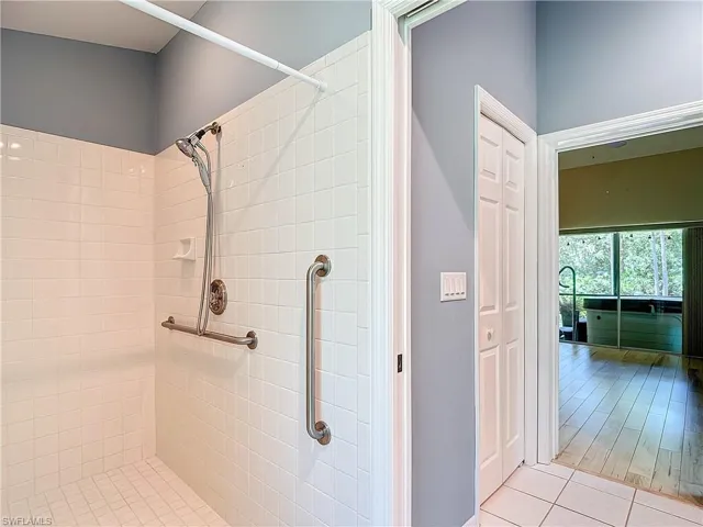 Bathroom with a tile shower and hardwood / wood-style flooring