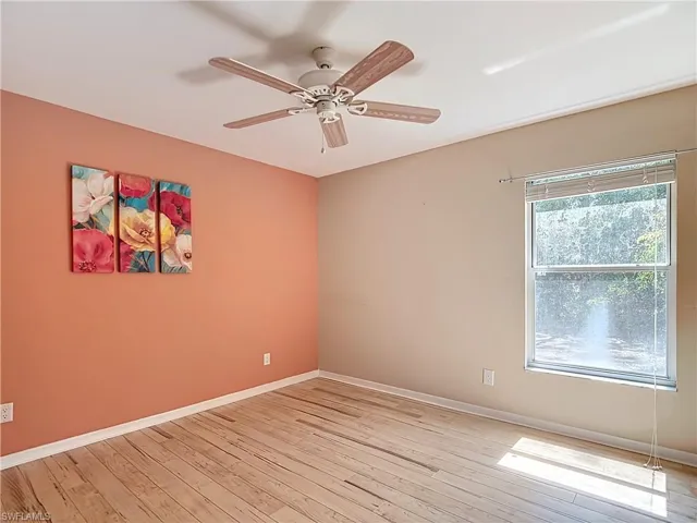 Empty room with ceiling fan and light hardwood / wood-style flooring