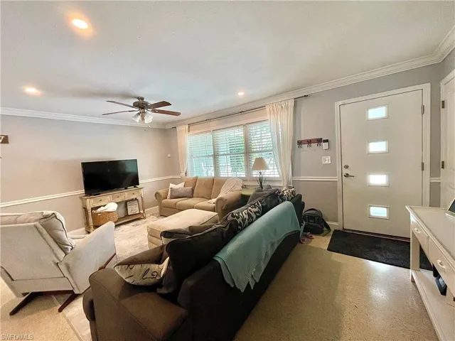 Living room with crown molding and ceiling fan