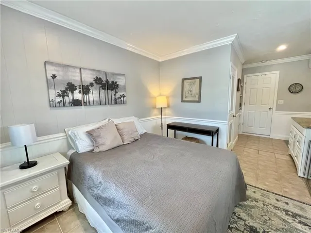 Tiled bedroom featuring crown molding