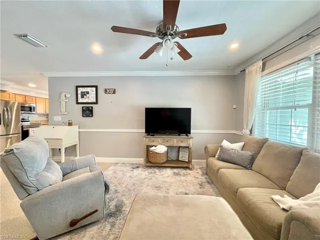 Living room featuring ceiling fan and crown molding