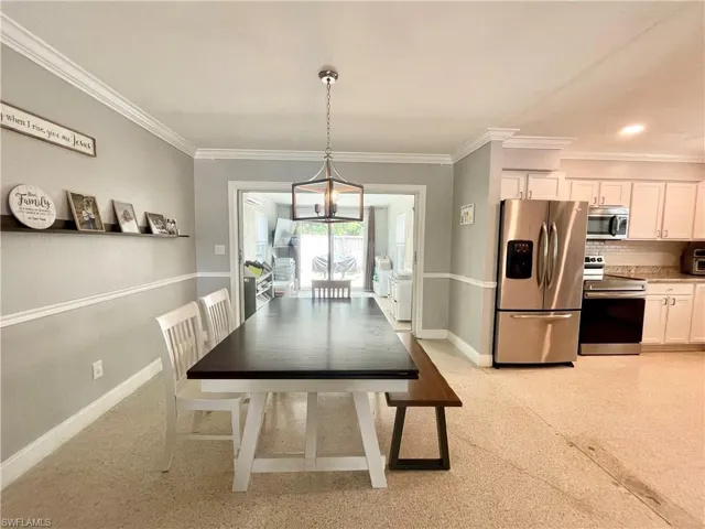 Dining space featuring a notable chandelier and ornamental molding