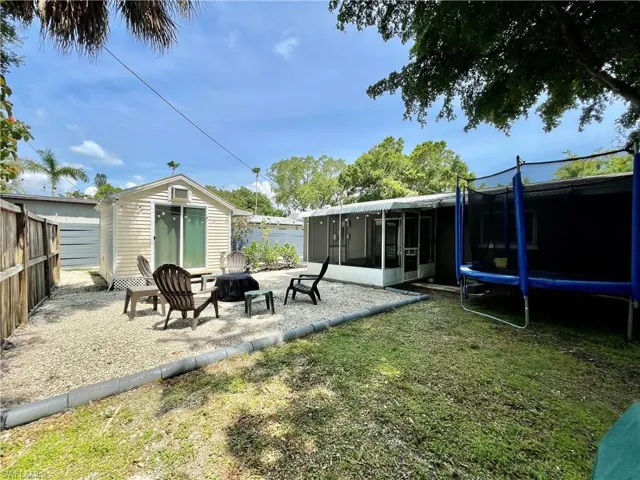 View of yard featuring a sunroom and a trampoline
