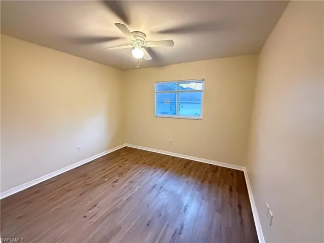 Empty room with wood finished floors and a ceiling fan