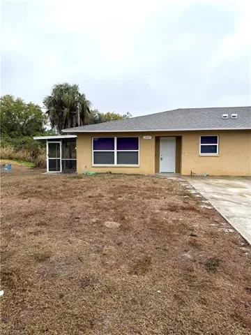 View of front of house featuring stucco siding, a sunroom, and a shingled roof