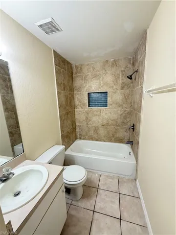 Bathroom featuring shower / bath combination, vanity, and tile patterned floors
