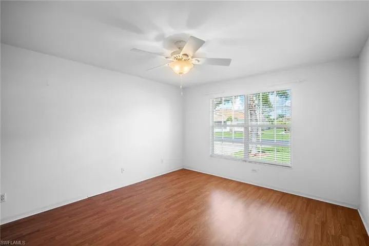 Unfurnished room with ceiling fan and hardwood / wood-style flooring