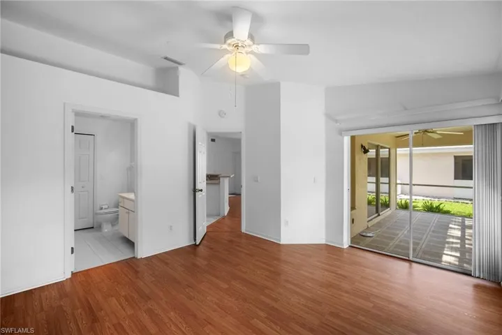 Unfurnished room featuring light wood-type flooring, ceiling fan, and lofted ceiling