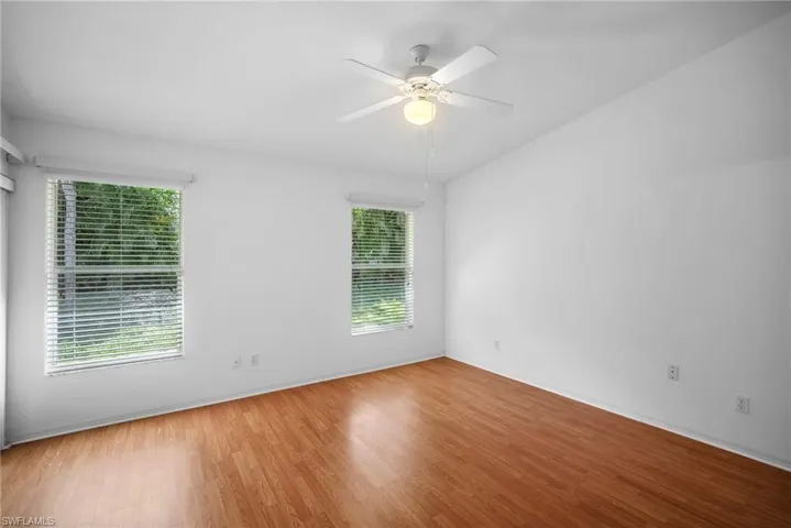 Spare room featuring a healthy amount of sunlight, light hardwood / wood-style floors, and ceiling fan