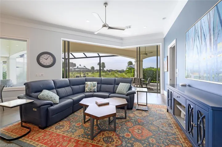 Living room with hardwood / wood-style flooring, crown molding, and plenty of natural light