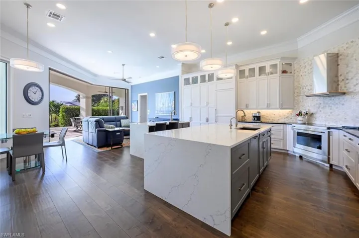 Kitchen featuring white cabinetry, dark hardwood / wood-style flooring, light stone countertops, wall chimney exhaust hood, and stainless steel electric range oven