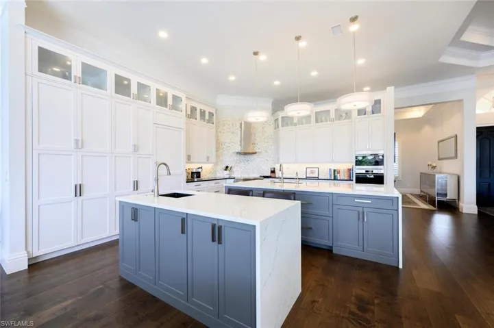 Kitchen with white cabinetry, a spacious island, and dark hardwood / wood-style flooring