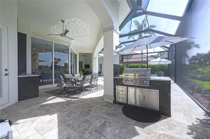 View of patio with ceiling fan, a grill, and an outdoor kitchen
