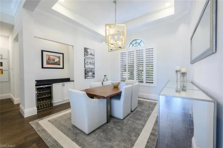 The Formal Dining room with designer chandelier, beverage cooler, built-in buffet with cabinet storage and Plantation Shutters