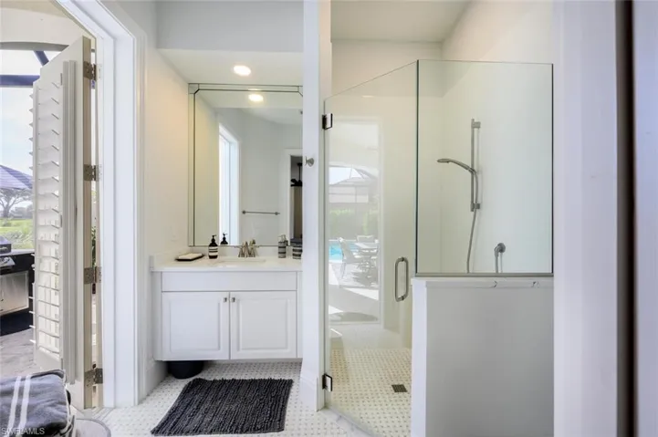 Bathroom with vanity, a shower with door, and tile patterned flooring