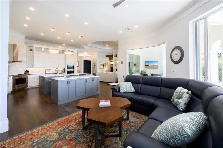 Living room with ornamental molding, dark hardwood / wood-style floors, and a wealth of natural light