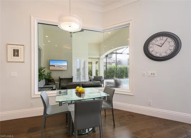 Dining space with dark hardwood / wood-style floors and ornamental molding