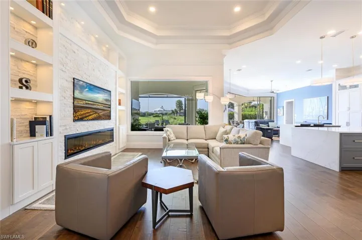 Living room featuring, Custom Stone wall with built-in lighted book cases, trey ceiling and recessed lighting