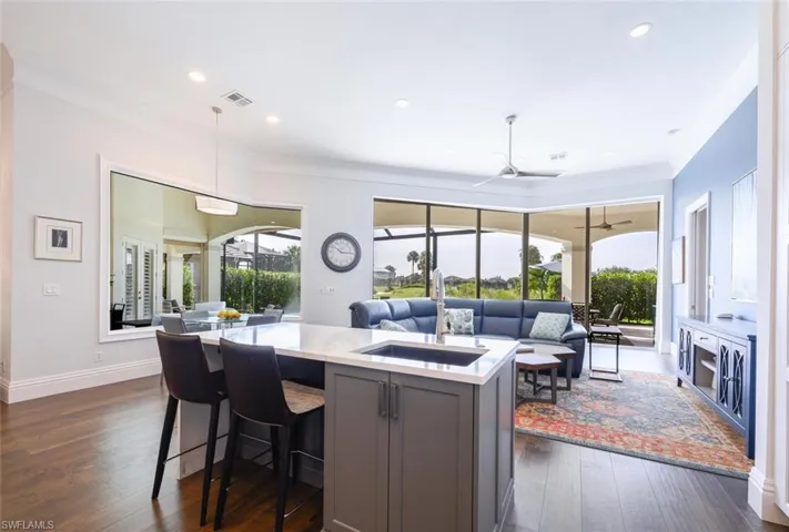 Kitchen with sink, pendant lighting, a kitchen island, dark hardwood / wood-style flooring, and ceiling fan