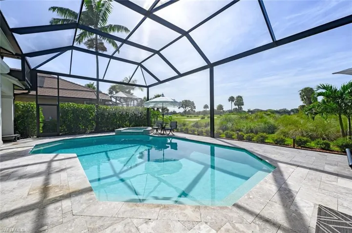 View of swimming pool featuring a patio area and glass enclosure