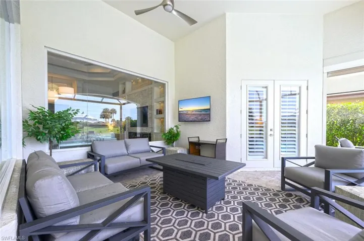 Tiled living room featuring ceiling fan and a high ceiling