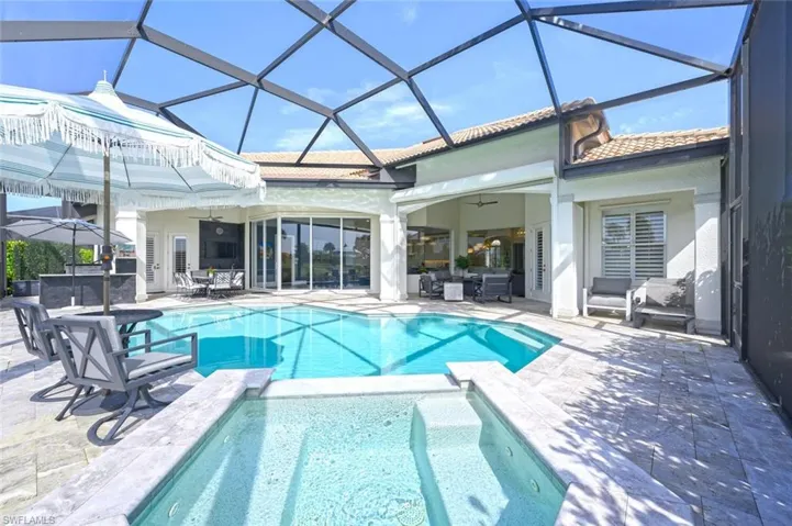View of pool with outdoor lounge area, a patio, ceiling fan, and glass enclosure