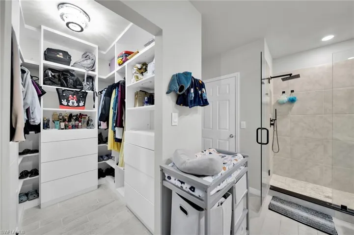 Walk in closet with wood finish floors