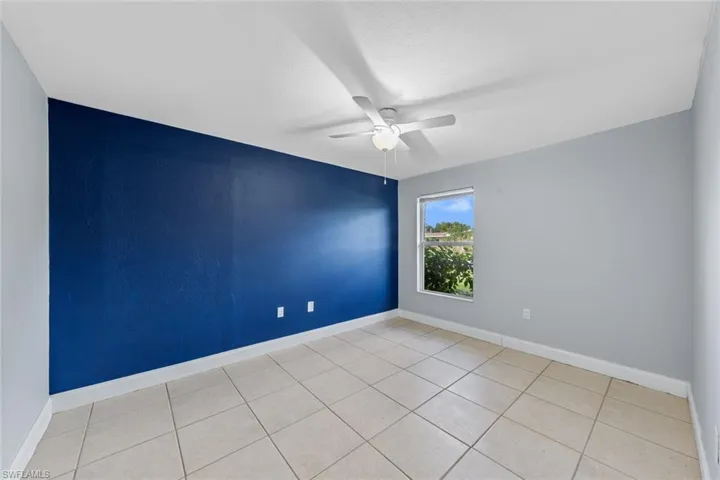 Spare room with ceiling fan and light tile patterned flooring