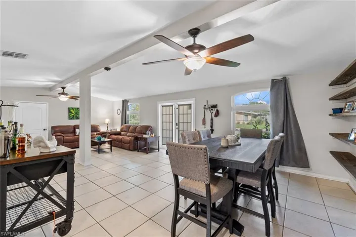 Tiled dining area with beamed ceiling and ceiling fan