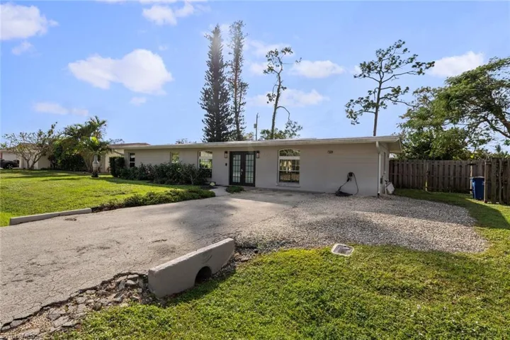 Ranch-style home with french doors and a front lawn