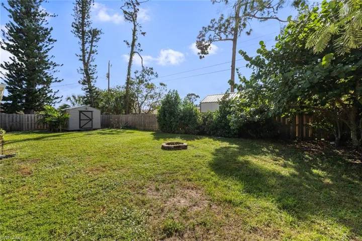 View of yard with a shed and a fire pit