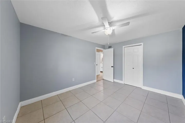 Tiled spare room featuring ceiling fan and a textured ceiling