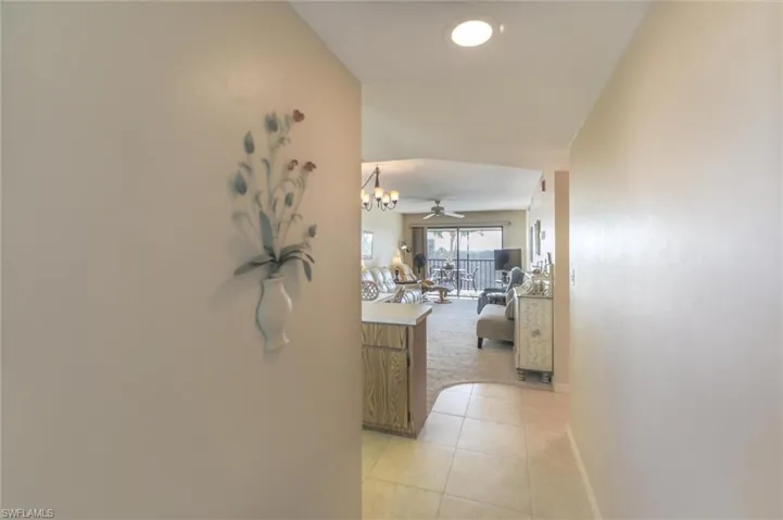 Hall with a notable chandelier and light tile floors