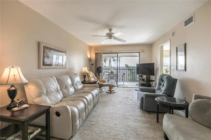 Living room featuring ceiling fan and carpet floors