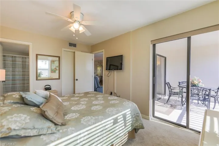 Carpeted bedroom with ceiling fan and access to outside