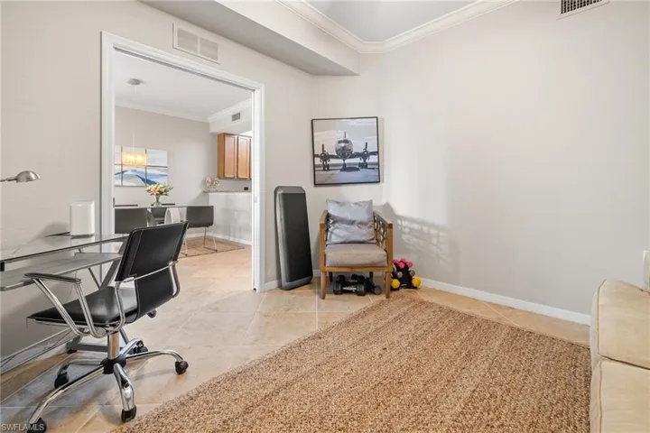 Home office featuring light tile patterned floors and crown molding