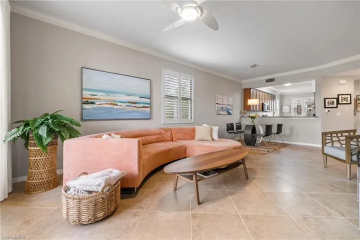 Tiled living room featuring ornamental molding and ceiling fan