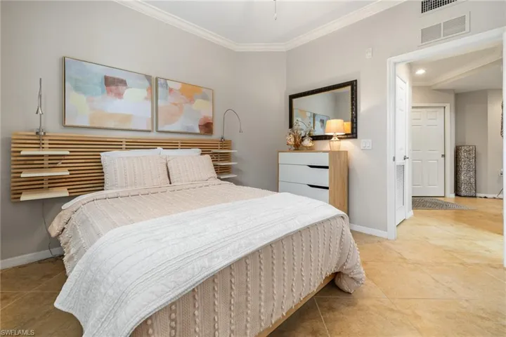 Bedroom featuring light tile patterned flooring and crown molding