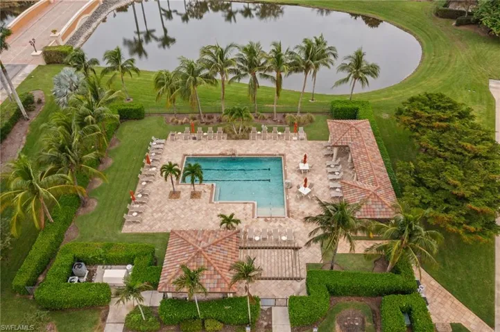 View of swimming pool featuring a lawn, a water view, and a patio area