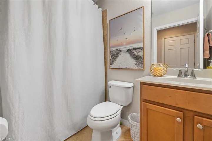 Bathroom featuring tile patterned flooring, vanity, and toilet