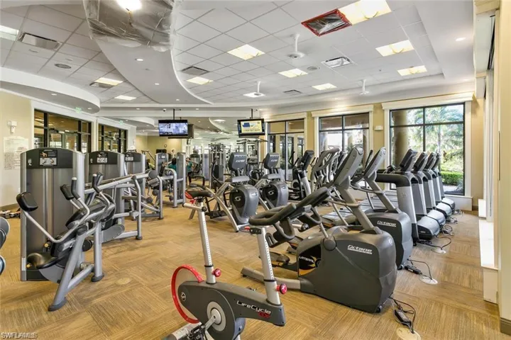 Gym with light colored carpet and a paneled ceiling