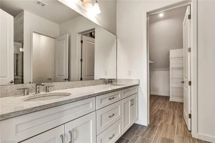 Primary bathroom with dual sinks and luxe walk-in shower