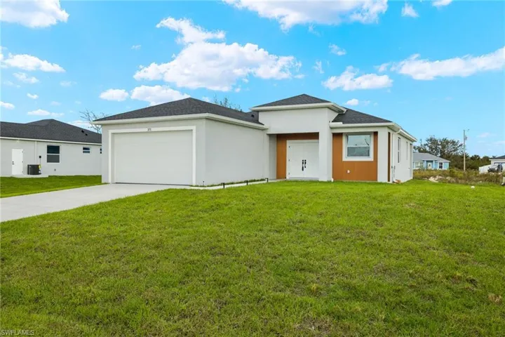 View of front of property featuring a front yard and a garage